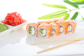 Sushi roll on white plate with ginger and wasabi