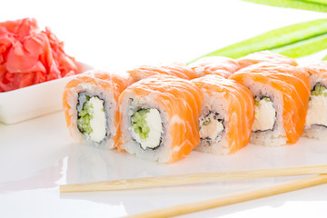 Sushi roll on white plate with ginger and wasabi