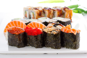 Sushi rolls and gunkans over white background