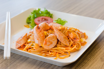 spaghetti with sausage on wood desks