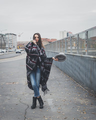 Beautiful young brunette posing in the city streets