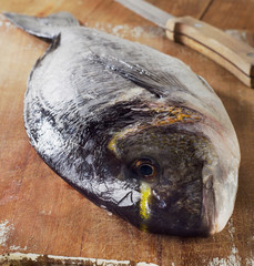 Fresh sea bream on a wooden cutting board
