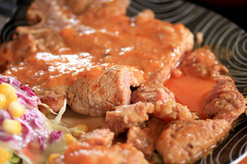 Steaks, pork, french fries with salad.