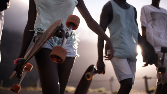 Teen longboarders looking cool walking together