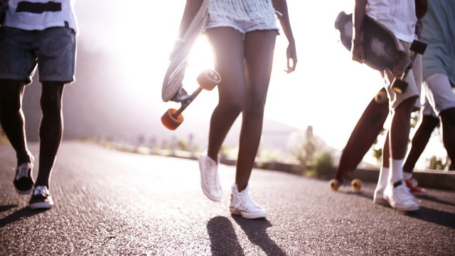 Teen longboarders looking cool walking together