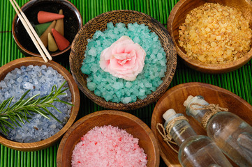Obraz na płótnie Canvas colorful sea salt ,orchid flower in wooden bowl ,green leaf on green mat