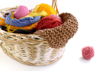 .wicker basket with balls of yarn and knitting needles