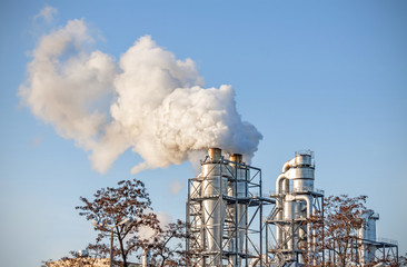 Smoking chimenys over blue sky, air pollution concept.