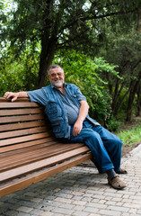 Fototapeta premium grandfather in the park relaxing on the grass
