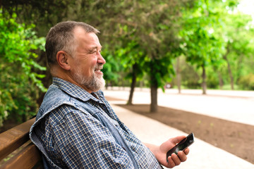 old man with the phone in the park