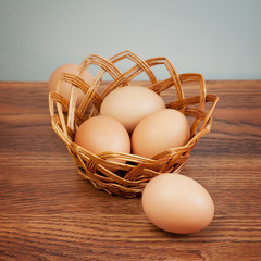 Fototapeta na wymiar Eggs in a basket on wooden table
