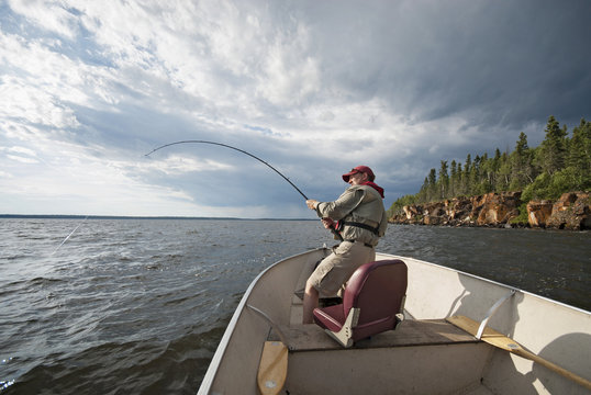 Man fishing from boat on lake