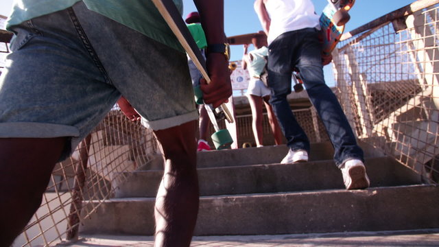 Teenagers wearing sneakers coming up steps in an urban setting