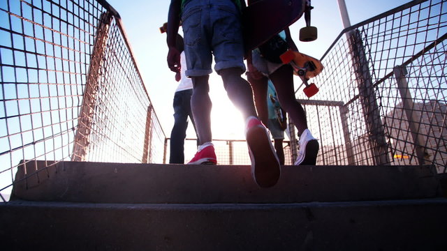 Teenagers wearing sneakers coming up steps in city