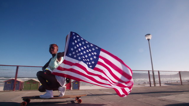 African American longboarder flying an American flag