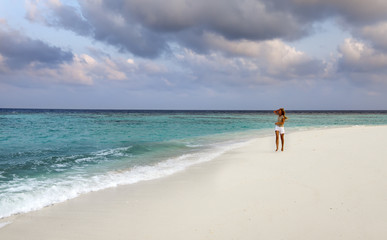 The woman runs on sea coast, Maldives