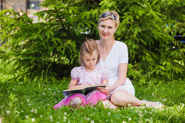 Fototapeta premium Little girl and her mother reading a book