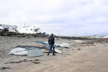 windsurfers vans and boards by the beach