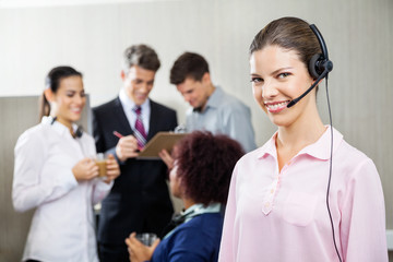 Happy Female Service Agent Standing At Call Center