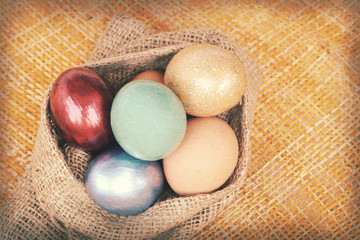 Vintage paper texture, colorful easter eggs in sack bag on weave
