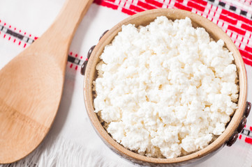 curd in brown bowl on the Ukrainian rushnyk