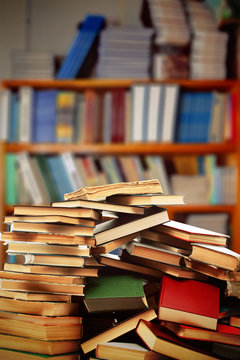 Many books on table on bookshelves background