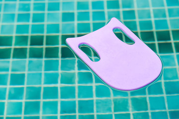 Blue foam board for the teaching of swimming beside swimming poo