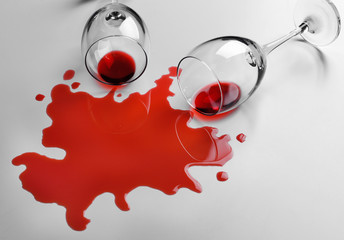 Red wine spilled from glass on white background