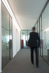 Business man walks in a hallway
