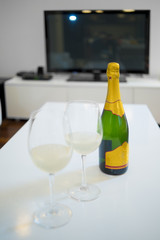 Bottle and glass of champagne in a living room