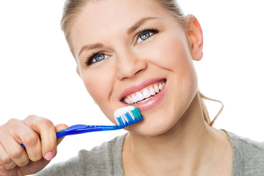Pretty smiling woman with perfect white teeth holding toothbrush
