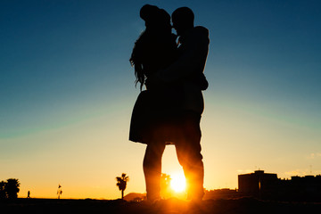 Couple silhouette is kissing at the sunset on the beach - 80455254
