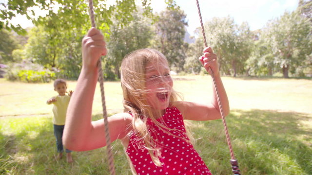 Friendly children swinging in a sunny park