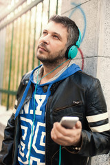Young man with headphones playing with smart phone