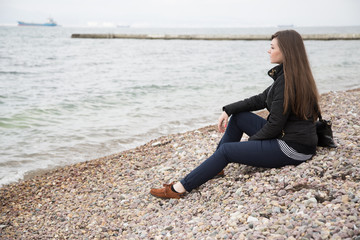 Fototapeta na wymiar Girl sitting by the sea