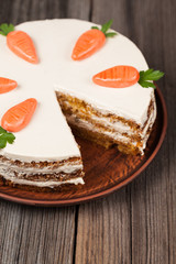 Sliced gourmet carrot sponge cake with icing cream and little
