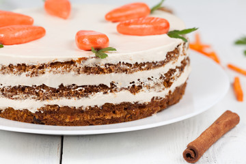 Tasty easter carrot cake with cream and little carrots on white