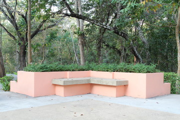 Modern orange concrete bench in garden.