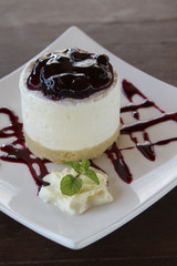 Blueberry cheesecake on white plate closeup.