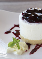 Blueberry cheesecake on white plate closeup.