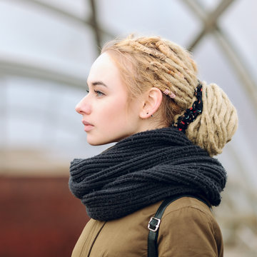 Closeup portrait of young blonde woman with a dreadlocks bun