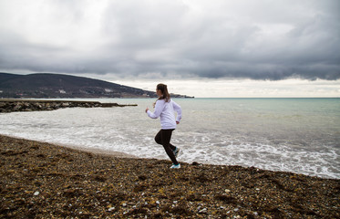 The girl runs along the beach