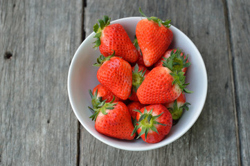 Strawberries in White bowl  on wood background