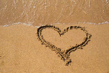 Painted heart in the sand on the beach