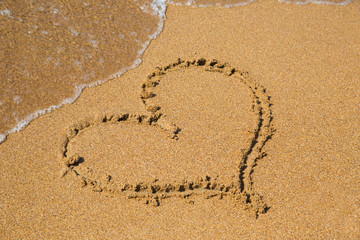Painted heart in the sand on the beach