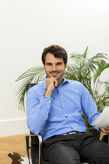 Young handsome man sitting at his desk in the office