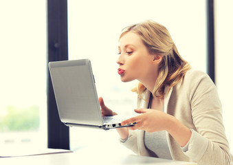 woman with computer kissing the screen
