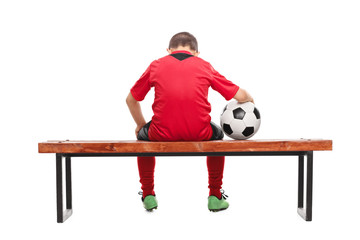 Naklejka premium Rear view of a sad little boy in soccer jersey