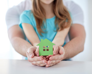 close up of man and girl hands with paper house