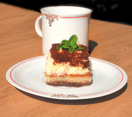 Cup of coffee and piece of cake tiramisu